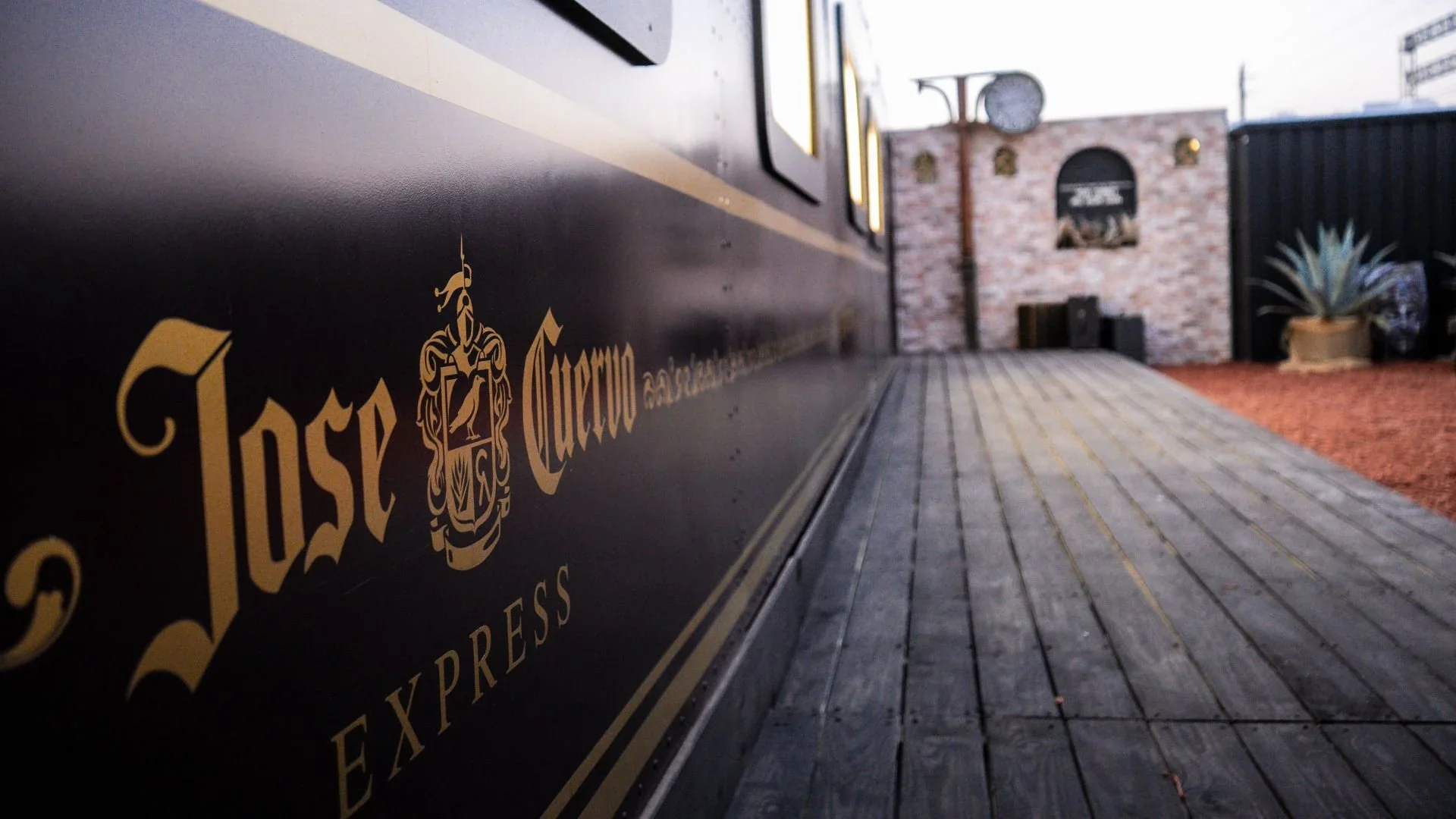 The black and gold Espíritu Express train car beside its wooden platform