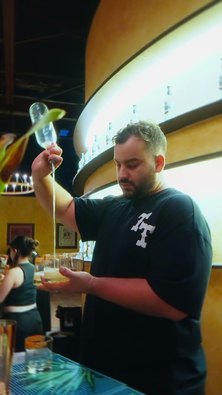A bartender pours a cocktail at the Tequila Town bar